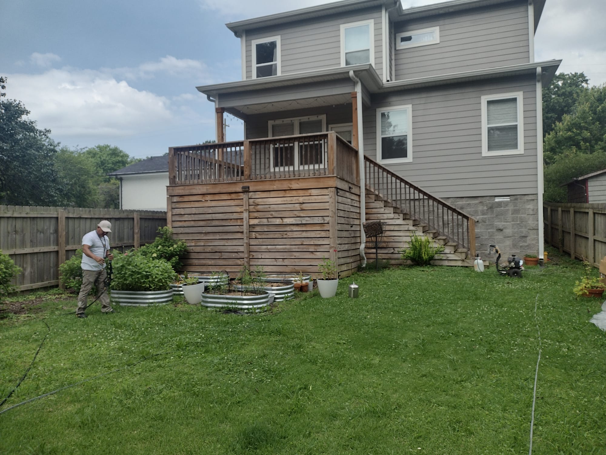 Exterior painting — gray two-story house with freshly stained deck
